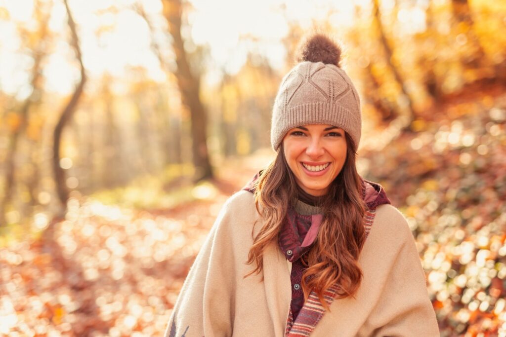 Woman Walking Through The Forest On A Sunny Autumn Day